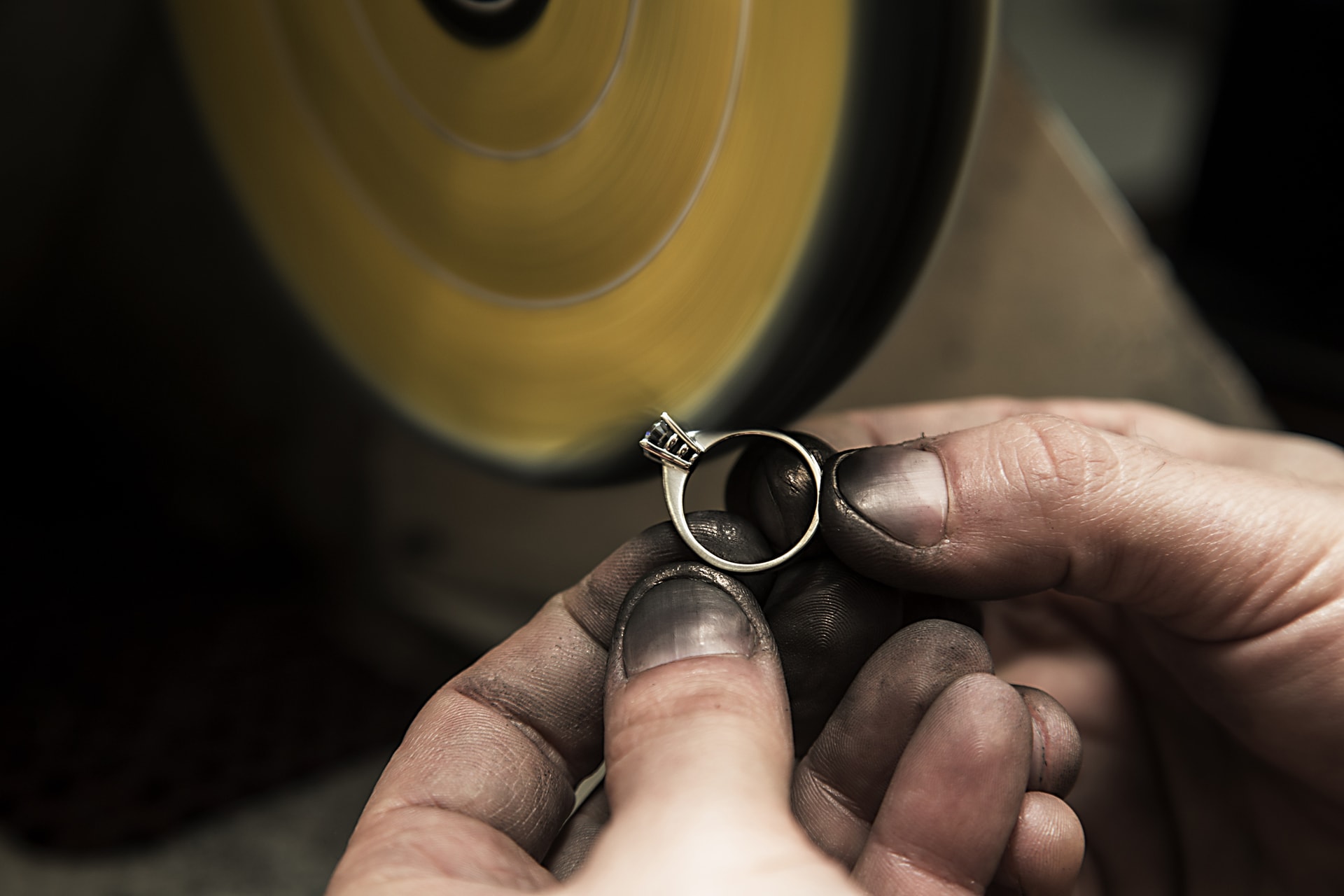 Jerweler using polishing machine on a ring